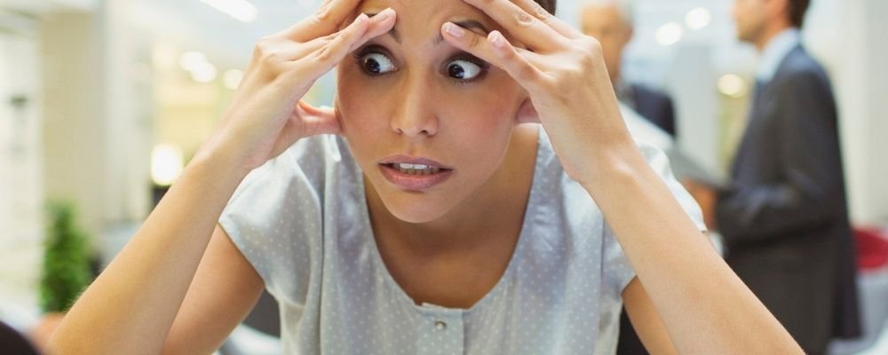 Woman with hands against her forehead has a panic attack