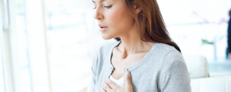 Woman breathing hard with hand on chest