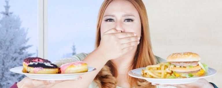 Woman with hand over mouth, unhealthy food